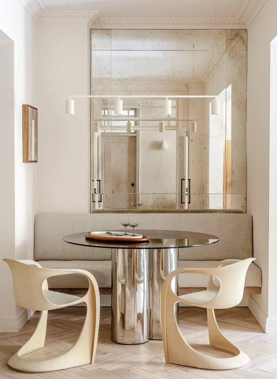 Minimalist dining nook in soft beige tones with sculptural chairs, light wood finishes, and a clean, serene atmosphere.