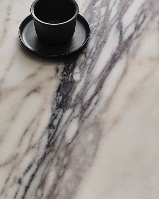 Anatolia_Aeterna_Finish-Honed-Calacatta-Picasso Medium Close-up of honed marble-look tile with soft veining and matte finish, highlighting natural variation and subtle surface texture
