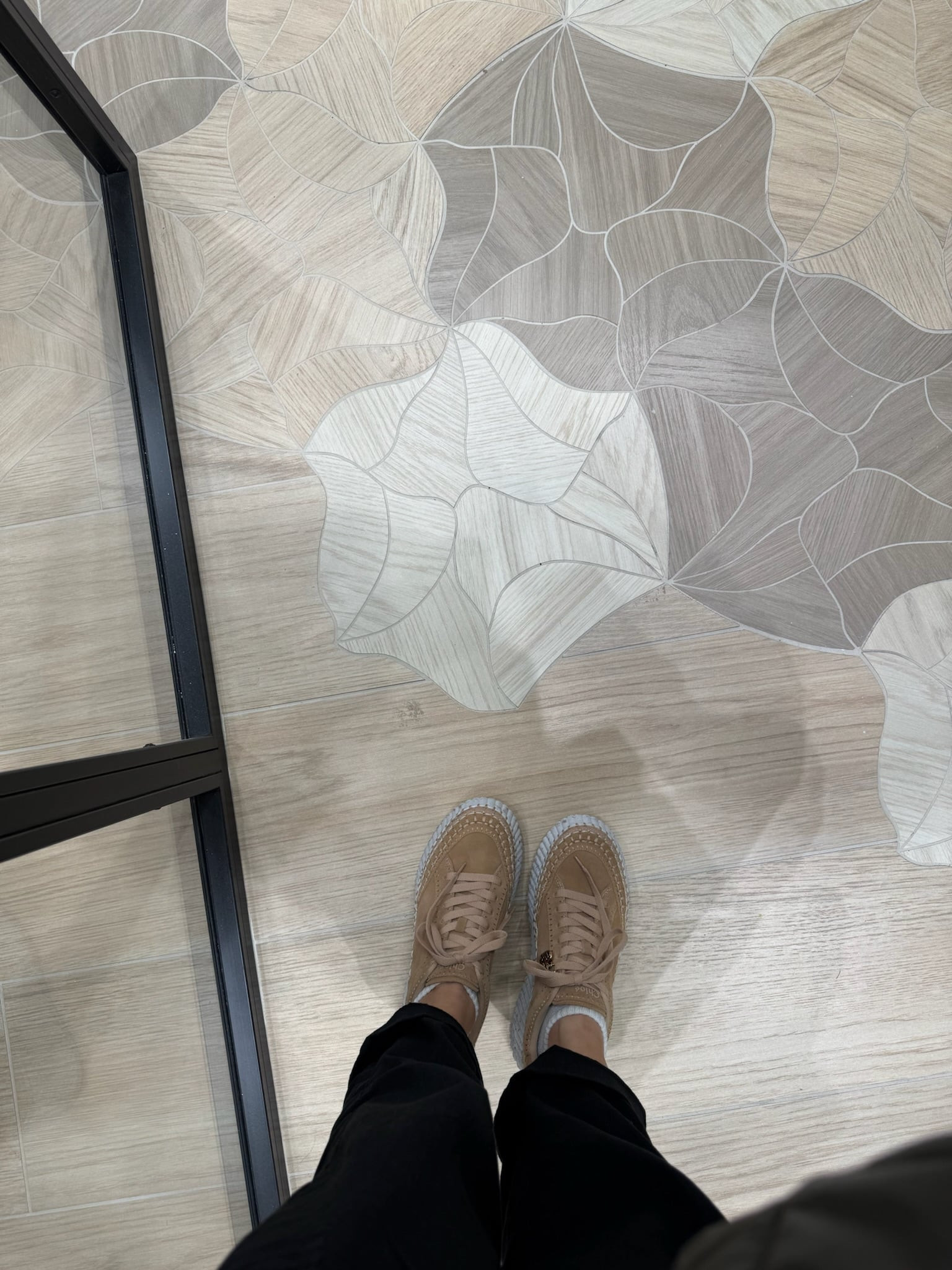 Patterned Tile Flooring — Coverings 2026 Close-up view of patterned tile flooring at Coverings 2026, featuring geometric shapes and soft tonal variation in neutral hues