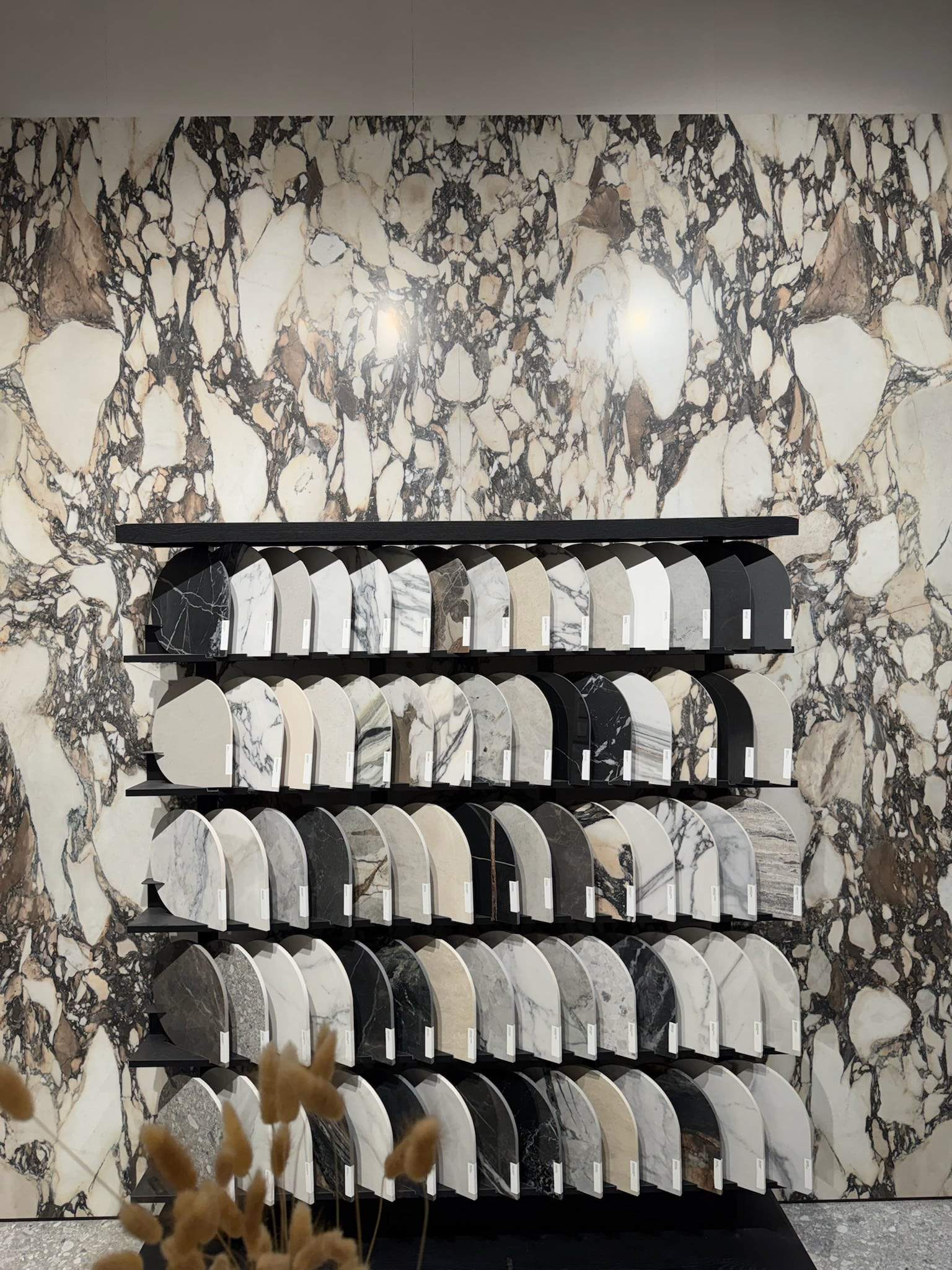Expressive Marble Tile — Coverings 2026 Expressive marble-look tile wall with bold veining and high contrast, creating a dramatic and artistic surface in a showroom setting